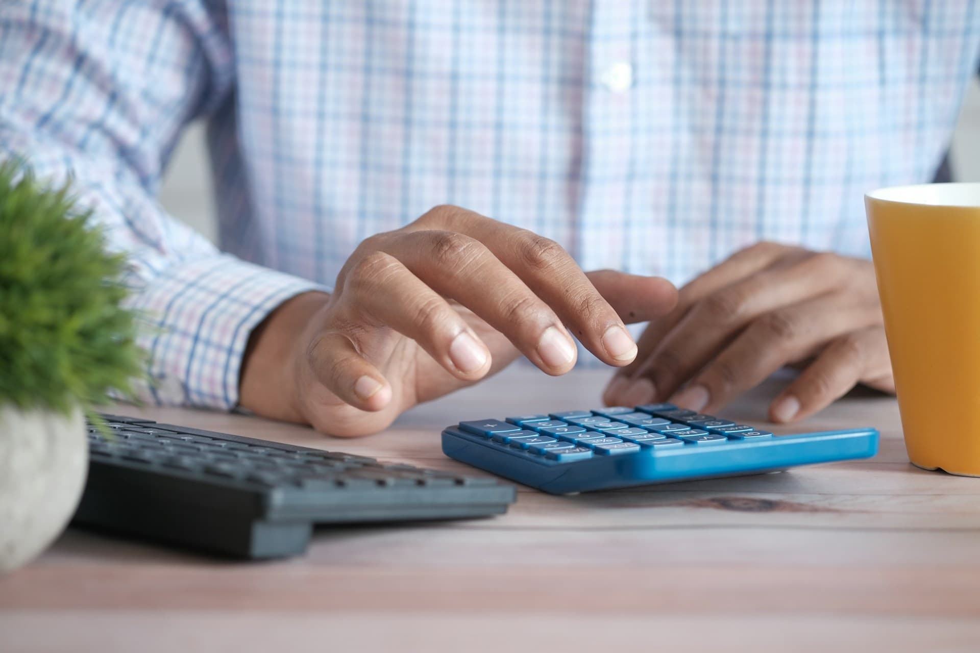 Man calculating Amazon fees using a calculator
